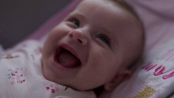 一个小婴儿微笑和大笑的特写视频
