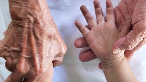 拉近祖母牵着孙子的手爱家庭保健医身体部份祖父母的爱