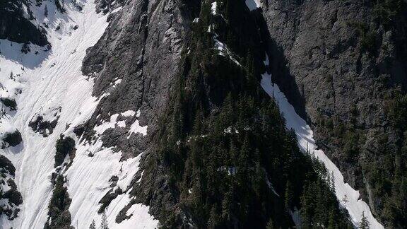 在春季气温升高的山坡上直升机在空中拍摄融化的积雪