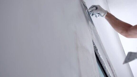 施工现场粉刷改造墙的过程建筑工人用金属铲将水泥墙面对准白浆灰泥完成公寓或住宅的维修工作混凝土墙的维护