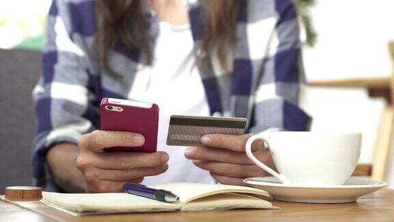 年轻女性用信用卡在智能手机上网购