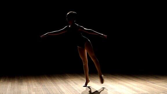 一个芭蕾舞者在黑色背景上摆姿势