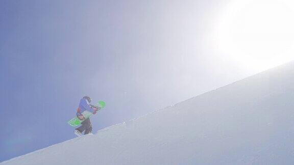 慢动作:年轻的滑雪板手拿着滑雪板上山