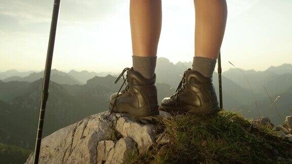 慢镜头:女游客穿着皮靴登山到达山顶