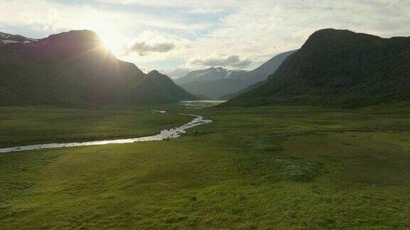 阳光照耀着美丽的约顿海门国家公园温暖的田野宁静的河流空中无人驾驶飞机挪威