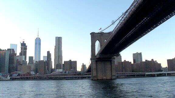 低角度视角:黎明时分沿着著名的布鲁克林大桥下的东河巡游
