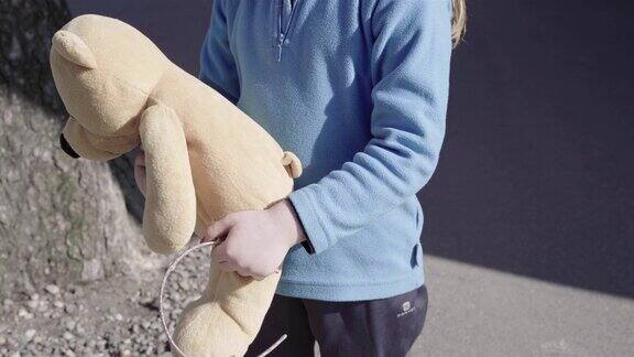 小女孩抱着她的泰迪熊的特写