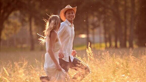SLOMOTS年轻夫妇在高草地上奔跑