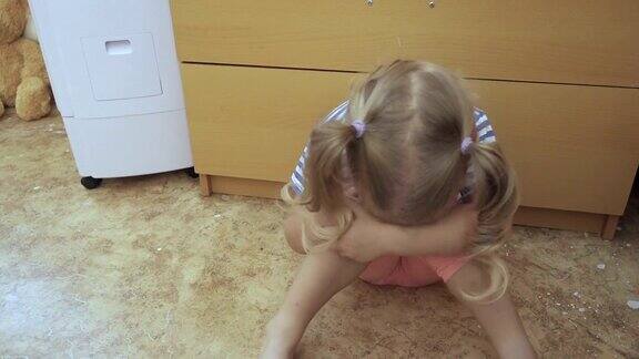 小女孩坐在房间的地板上哭泣