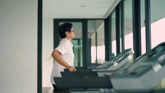 亚洲资深女性在跑步机上进行步行锻炼