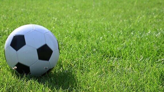 足球在绿色草地上滚动
