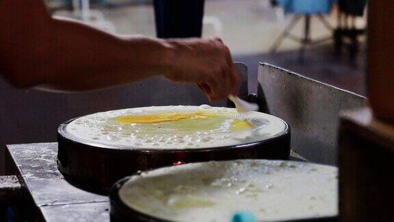 在夜市制作可丽饼甜点的特写泰国街头小吃