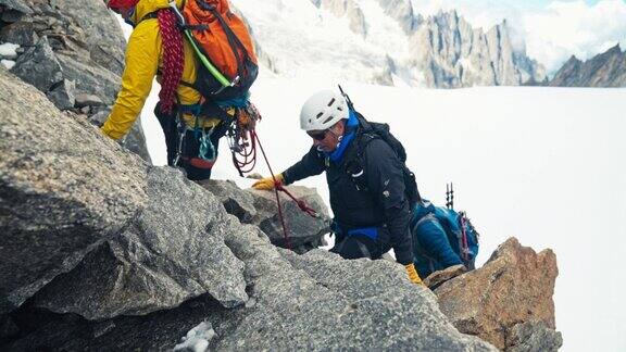 欧洲阿尔卑斯山脉上的山峰被冰山覆盖攀岩者在陡峭的岩壁上行走