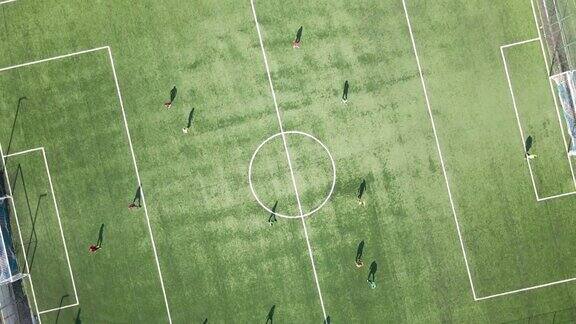 足球运动员在绿色体育场踢足球的鸟瞰图