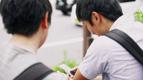日本学生在等公交车时使用智能手机
