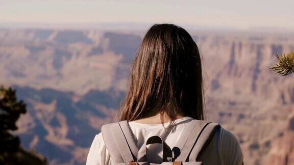 背景特写快乐的年轻女性游客背包观看史诗般的夏季全景大峡谷在美国亚利桑那州