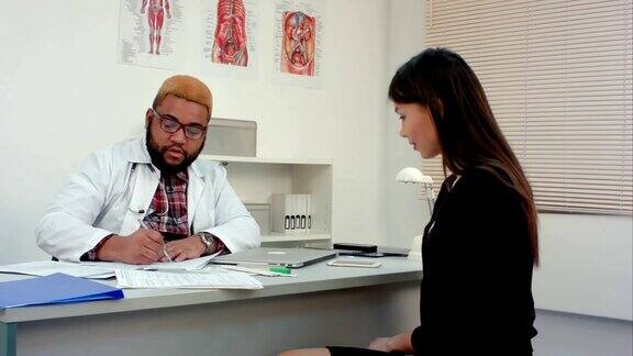 男医生与女病人交谈并填写医疗表格