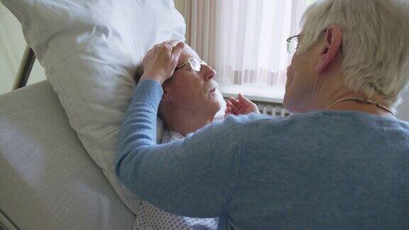 老妇人在医院病房探望生病的丈夫