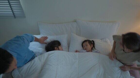 亚洲慈爱的父母在家里的卧室里照顾睡觉的女儿迷人的幸福家庭夫妇爸爸妈妈在早上的床上给舒服的睡着的小婴儿盖上毯子