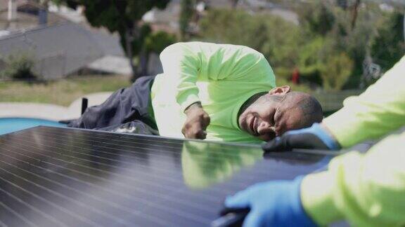 在加利福尼亚的住宅屋顶安装太阳能电池板的工人团队
