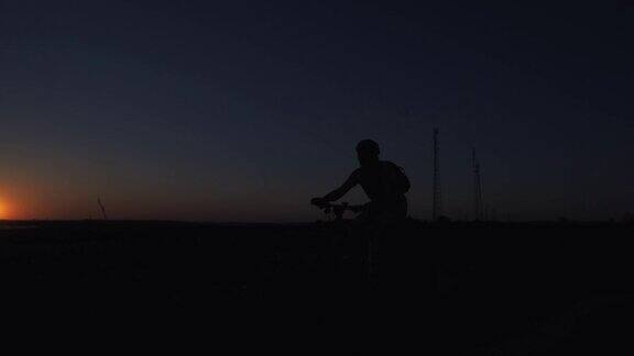 夕阳下骑自行车的人的剪影