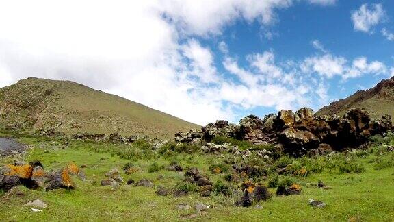 蒙古大草原中的一座小山脚下覆盖着苔藓岩石