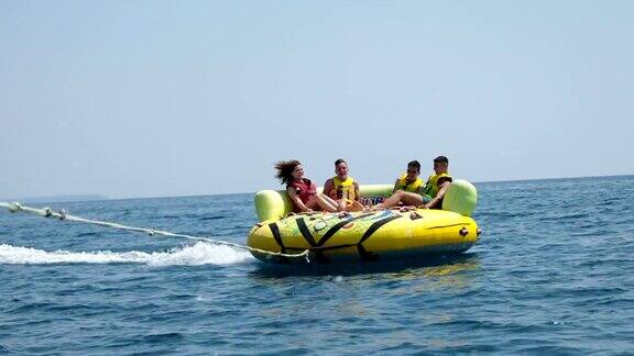 夏天的乐趣四个朋友在海上享受充气管道之旅