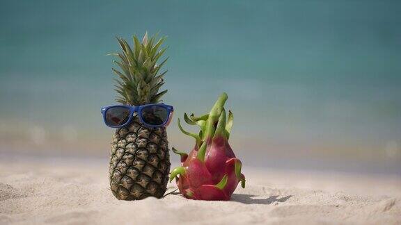 在海边的热带海滩上戴墨镜的成熟菠萝和粉红色的火龙果
