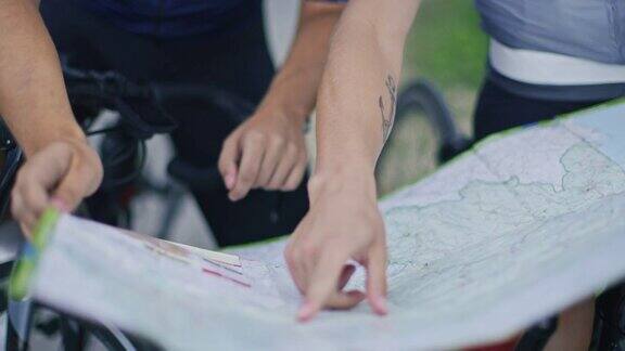 无法辨认的道路自行车手用地图规划他们的自行车之旅