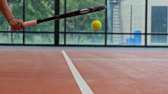 女子用球拍把网球从地上拿起网球的特写镜头