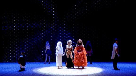 三个不同的女孩在剧院的舞台上一起唱歌