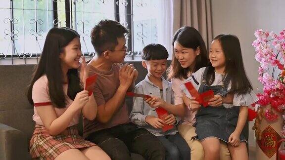 春节期间一个亚洲小孩在客厅里接受父母的春节红包