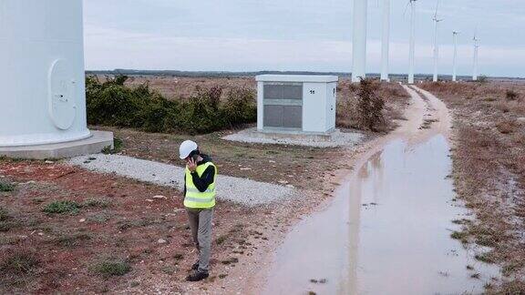 雨天在风力涡轮机农场工作的工程师可再生能源系统