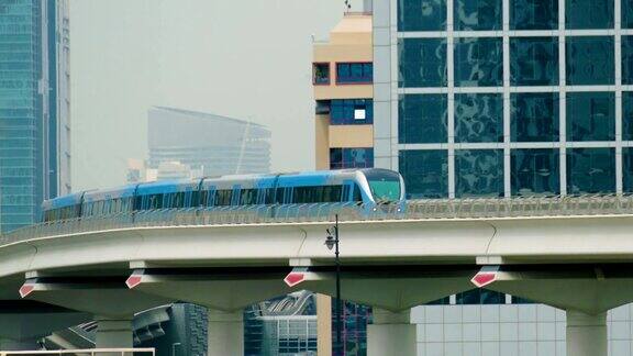 地铁在阿联酋迪拜的玻璃摩天大楼之间穿梭