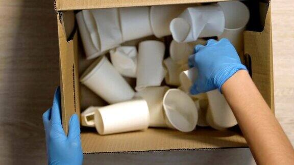 手给工人在手套盒纸杯和纤维素标志回收