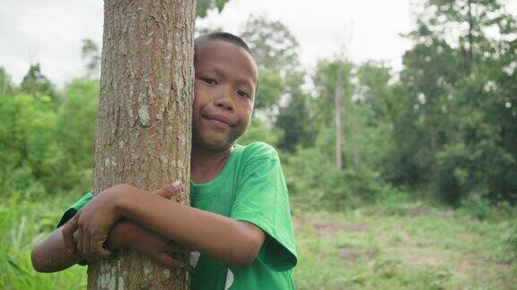 森林里的孩子拥抱着树地球日