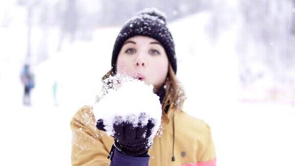 年轻女子是在冬天吹雪的大自然