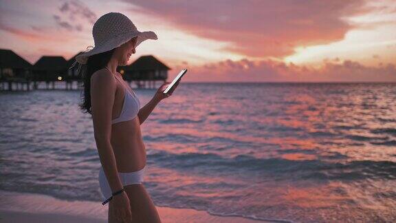 在海滩上用智能手机的女人