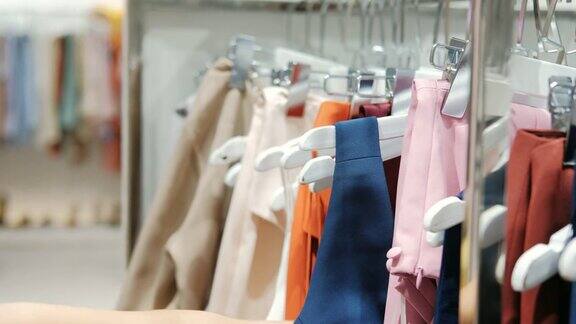 年轻的亚洲女人在商店购物中心选择衣服