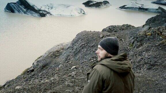 年轻英俊的男子徒步在Vatnajokull冰泻湖附近的山上看冰岛的冰川