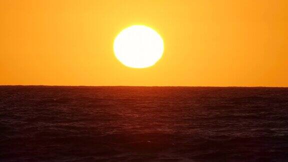 太阳在海上日落或黎明阳光透过海浪照耀