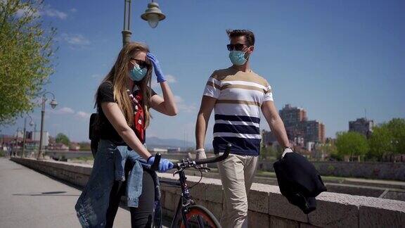 一对戴着防护手套和面罩的年轻夫妇正在散步和交谈