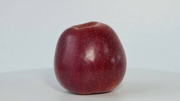 一个红苹果在旋转一个红苹果的微距镜头一个苹果在白色背景上绕着它的轴旋转