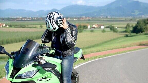 骑摩托车的女士脱下了头盔和手套