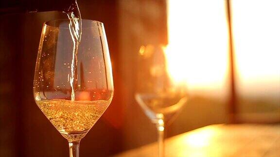 彩色日落时桌上浪漫的一杯葡萄酒落日时的一杯白葡萄酒