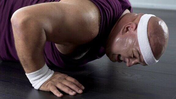 有动力的大个儿男人做俯卧撑流汗在家锻炼保健