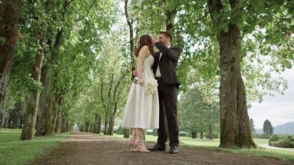 新娘和新郎在公园接吻