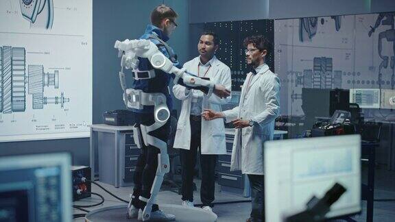 在机器人开发实验室:工程师和科学家工作的仿生学外骨骼原型与人测试它帮助残疾人和仓库工人设计可穿戴的防护服