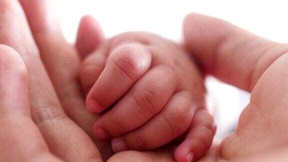 婴儿抱着父亲的手指