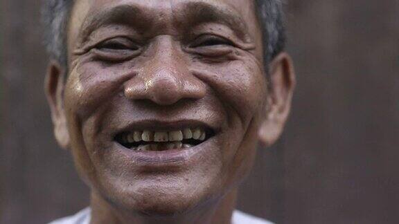 特写的成熟的亚洲男人微笑着看着相机